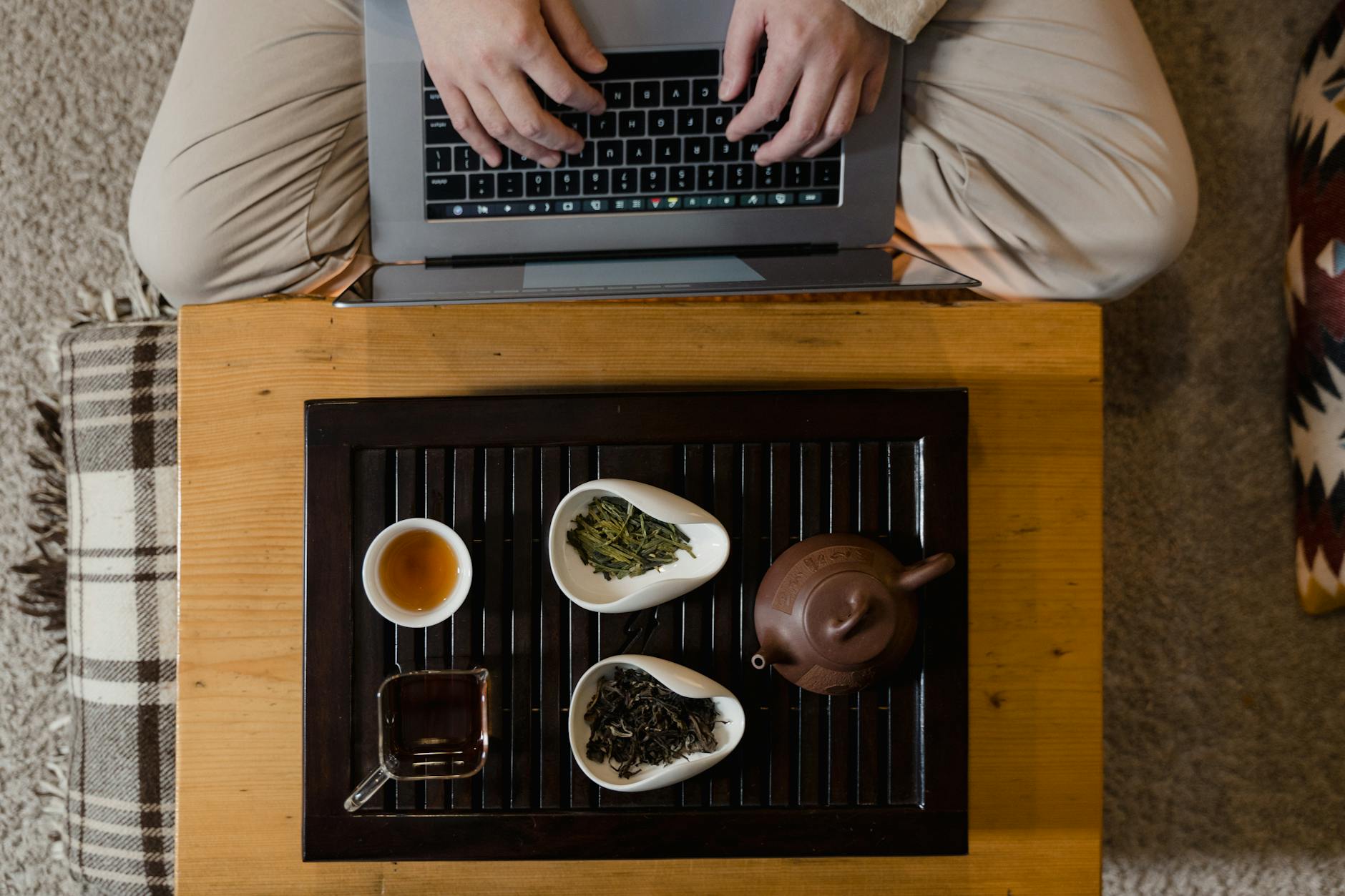 Laptop na biurku obok tradycyjnego zestawu do parzenia herbaty