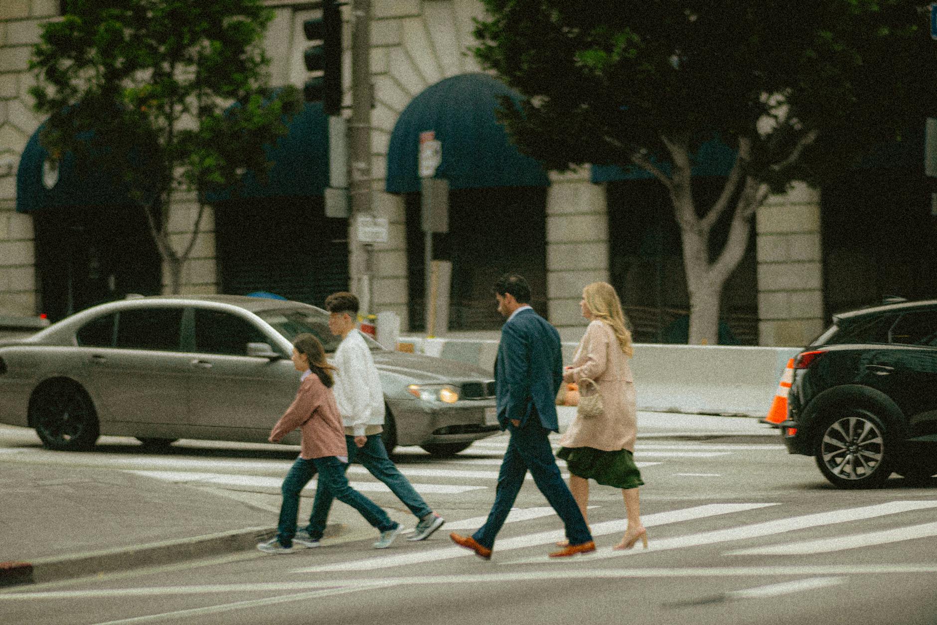 Rodzina z dziećmi przechodzi przez przejście dla pieszych w centrum Warszawy