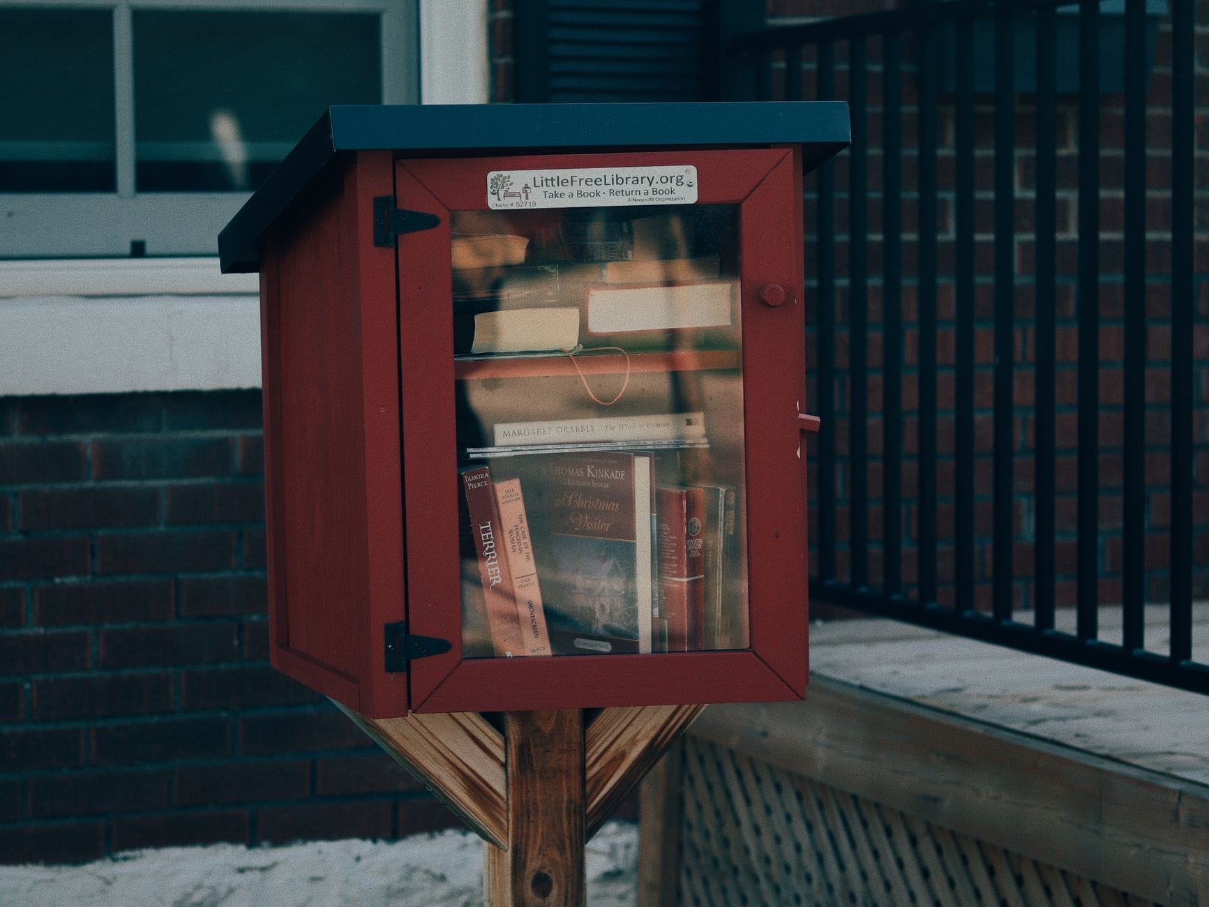 Czerwona skrzynka sąsiedzkiej biblioteczki plenerowej z książkami